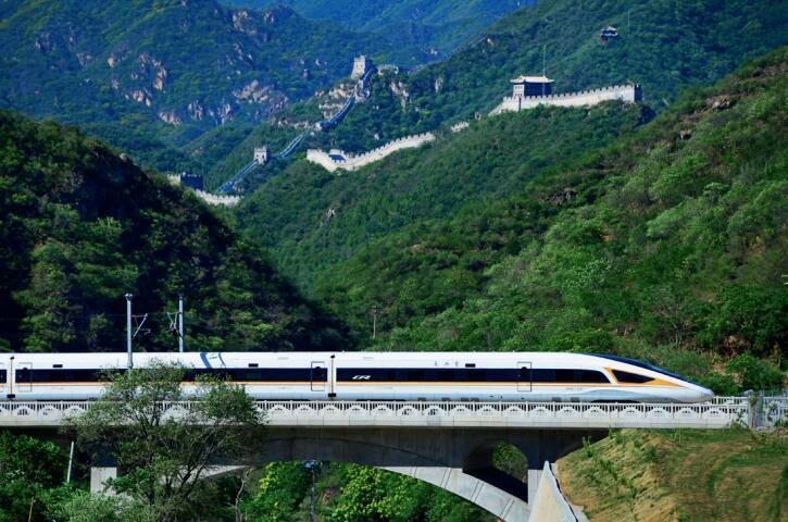 京張高鐵復(fù)興號(hào)動(dòng)車組行駛在長(zhǎng)城腳下。