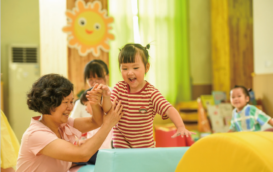 近年來，各地著力解決3歲以下嬰幼兒家庭入托難、入托貴等 問題，大力發(fā)展完善普惠托育服務(wù)體系，不斷增強(qiáng)人民群眾對普惠 托育服務(wù)的獲得感和滿意度，促進(jìn)嬰幼兒健康成長。圖為2024年 9月4日，江西省奉新縣示范幼兒園托育班的老師和孩子們在快樂 地玩耍。